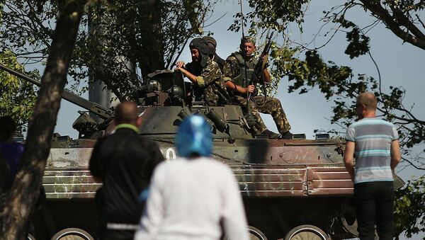 Местные жители наблюдают за украинским танком на окраине стратегического Мариуполя