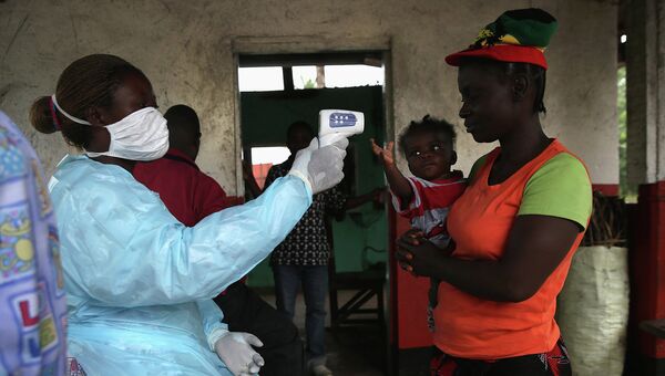Врач проверяет население на симптомы лихорадки Эбола, Либерия. Архивное фото