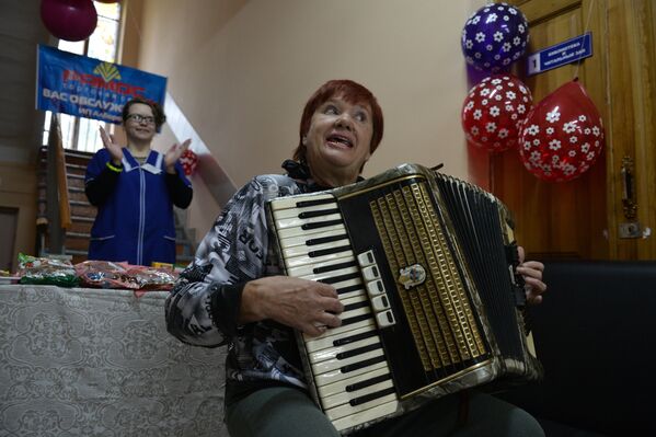 Женщина играет на аккордеоне на избирательном участке в Первомайском районе Новосибирска