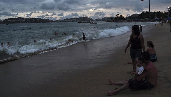 Люди на пляже в Мексике, во время приближения к берегу урагана Одиль