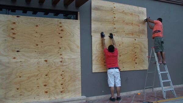 Рабочие укрепляют стену во время приближения урагана Одиль к берегам Мексики