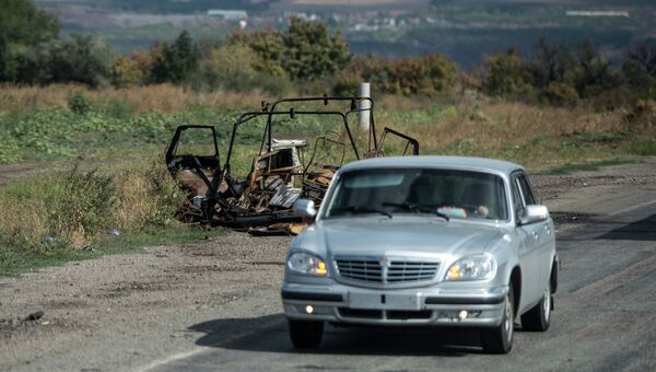 Сгоревшая машина у дороги на окраине Луганска