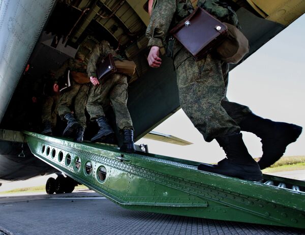 Российские военнослужащие во время посадки в транспортный самолет АН-12БК