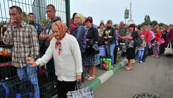 Украинские беженцы стоят в очереди на границе для возвращения в свои дома. 17 сентября 2014 года