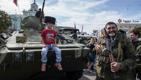 Мальчик сидит на бронетранспортере в Луганске