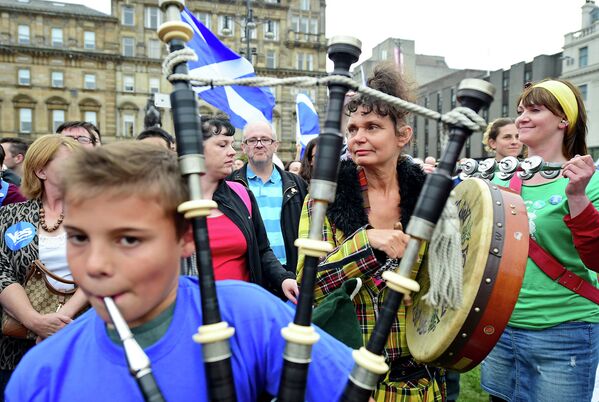 Волынщик и музыканты на улице Глазго перед окончанием голосования, Шотландия