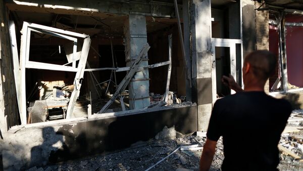 Мужчина у разрушенного дома после артобстрела в Макеевке под Донецком