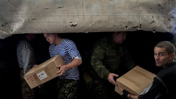 Мужчины разгружают один из грузовиков гуманитарной колонны на Украине. Архивное фото
