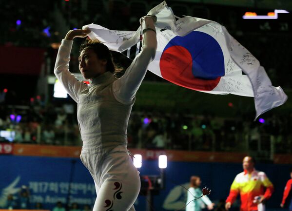 17-ые Азиатские игры в Южной Корее. Спортсменка из Южной Кореи, празднует завоевание золотой медали по  фехтованию