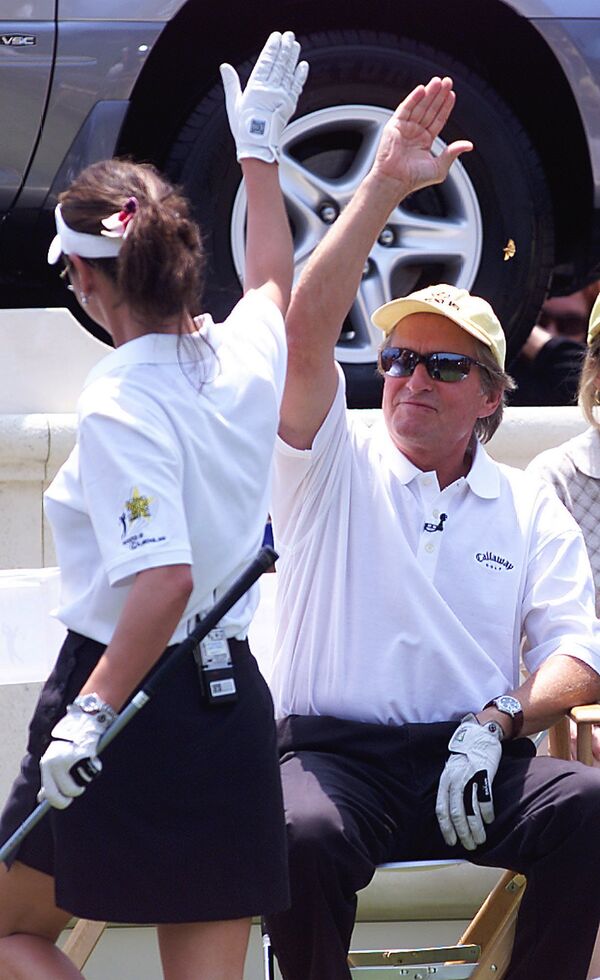 Кэтрин Зета-Джонс и Майкл Дуглаc во время игры в гольф. 2002 год