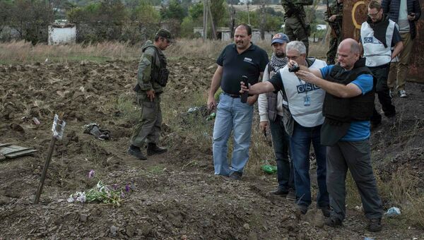 Наблюдатели ОБСЕ на месте захоронения мирных жителей в поселке Нижняя Крынка под Донецком