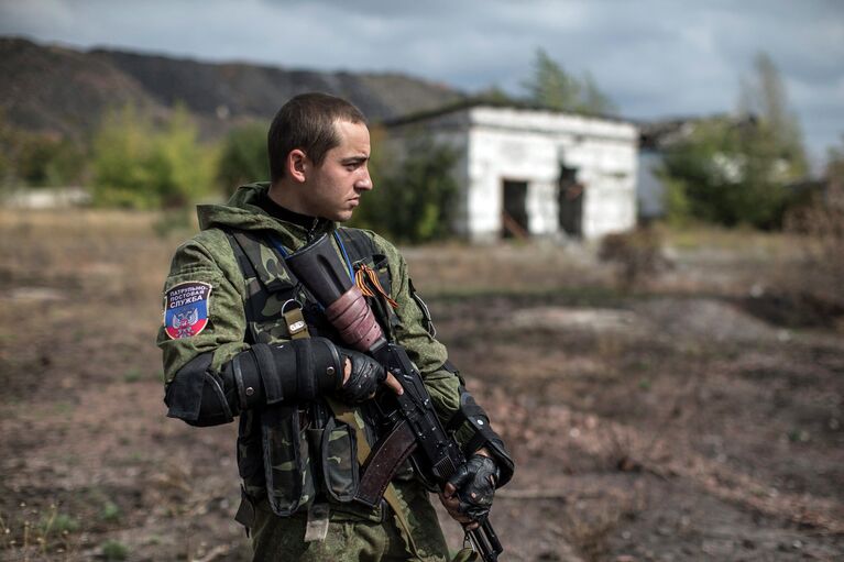 Боец народного ополчения возле места массового захоронения в поселке Нижняя Крынка