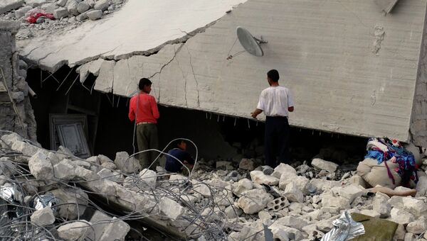 Сирийские жители осматривают разрушенные авиаударами США здания