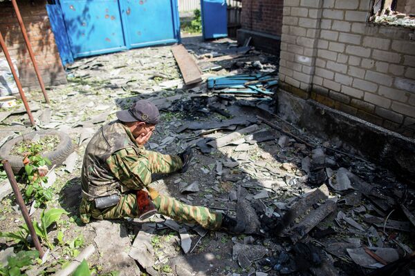 Ополченец из поселка Семеновка под Славянском во дворе своего дома, разрушенного в результате попадания снаряда во время ночного обстрела украинскими военными