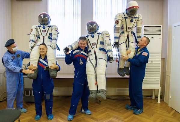 Члены основного экипажа транспортного пилотируемого корабля Союз ТМА-14М астронавт НАСА Барри Уилмор, космонавты Роскосмоса Александр Самокутяев и Елена Серова (справа налево) после примерки скафандров