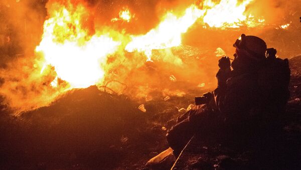 Журналист курит возле горящих покрышек на улице Грушевского
