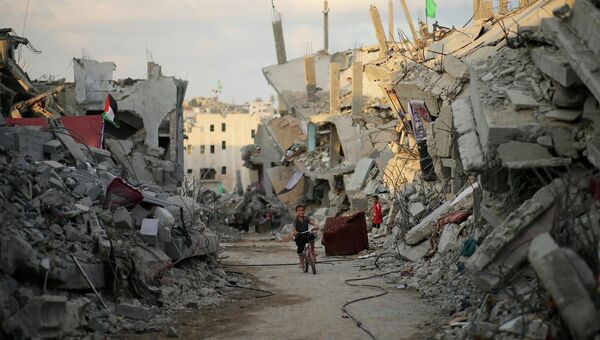 Мальчик на фоне разрушенных домов в Секторе Газа