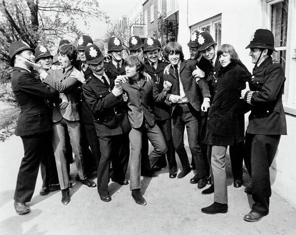 Музыканты группы The Beatles с полицейскими во время съемки фильма