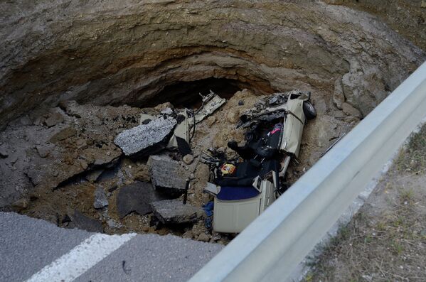 Автомобиль в яме, образовавшейся в результате обвала грунта на участке автодороги, соединяющей Евпаторийское и Николаевское шоссе у Симферополя