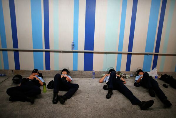 Полицейские отдыхают после столкновения с протестующими в Гонконге