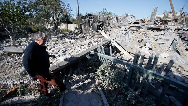 Женщина возле руин дома подвергшегося обстрелу украинскими военными
