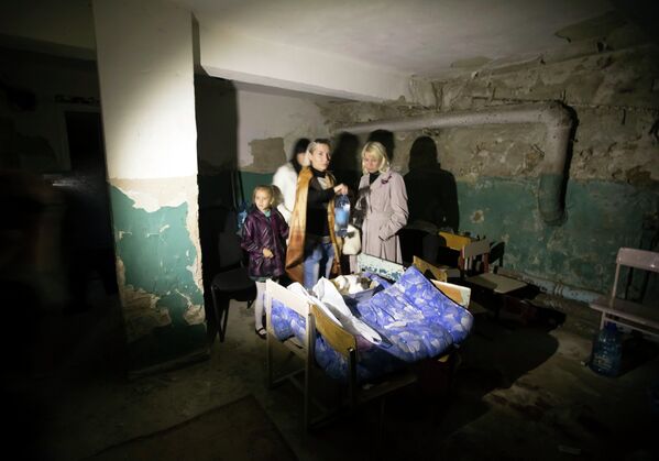 Дети с родителями прячутся в подвале после обстрела школы в Донецке