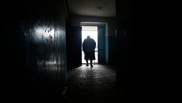 Пожилая женщина покидает здание после обстрела Донецка. Архивное фото