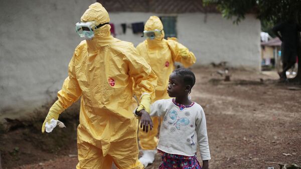 Медики и ребенком с подозрением на Эболу. Архивное фото