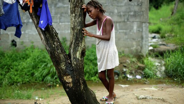 Девятилетняя жительница Монровии оплакивает свою мать, погибшую от лихорадки Эбола. Либерия, 2 октября 2014. Архивное фото
