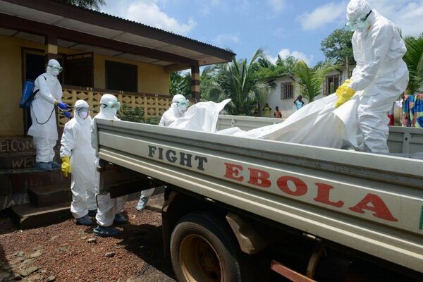 Либерийский персонал Красного Креста переносит тело погибшего от лихорадки Эбола в грузовик. Монровия, 4 сентября 2014