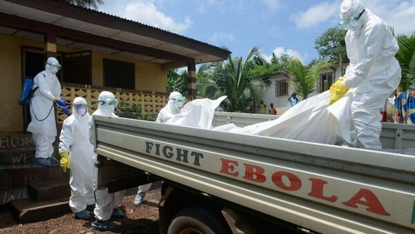 Либерийский персонал Красного Креста переносит тело погибшего от лихорадки Эбола. Архивное фото