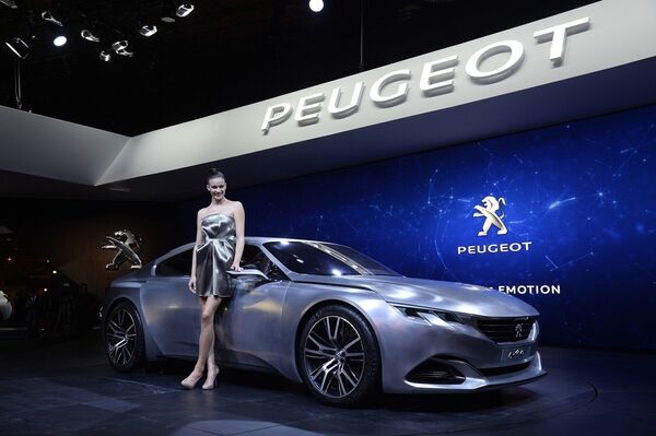 Модель позирует рядом с концепт-каром Peugeot Exalt на Парижском автосалоне