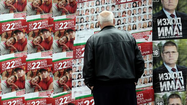 Житель города София смотрит на агитационные плакаты социалистической партии во время парламентских выборов в Болгарии. 3 октября 2014