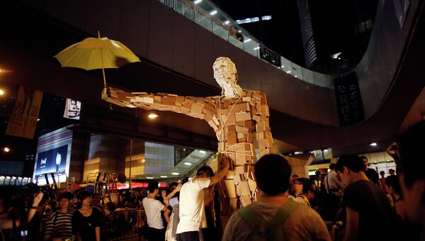 Протестующие устанавливают статую с желтым зонтиком, блокируя главную улицу финансового района Гонконга. 5 октября 2014