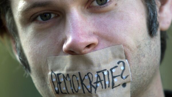 Демонстрант с заклеенным пластырем ртом на улице Мюнхена, Германия