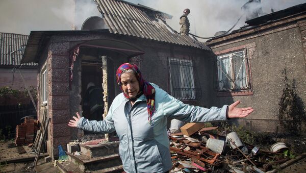 Жительница Донецка рядом со своим домом после артобстрела, архивное фото