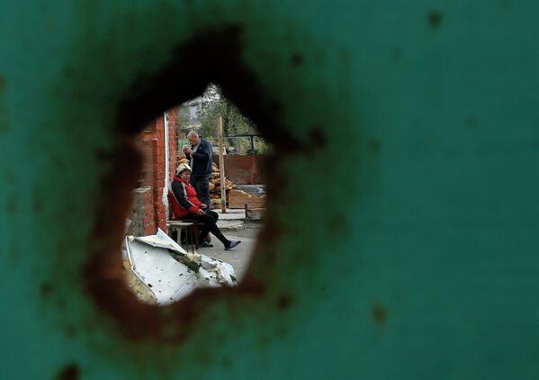 Жители Семеновки рядом с разрушенным в результате артобстрела домом
