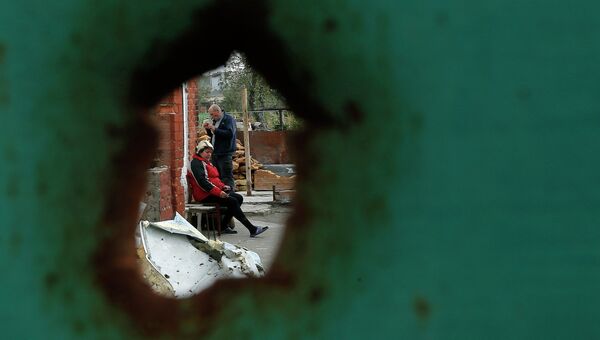 Жители Семеновки рядом с разрушенным в результате артобстрела домом