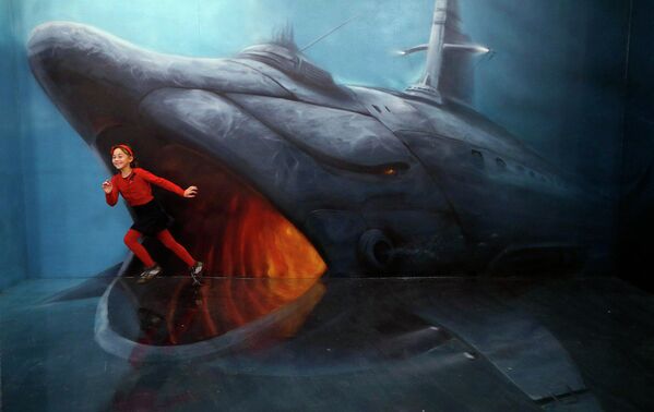 Девочка рядом с изображением акулы в Музее оптических иллюзий в Санкт-Петербурге
