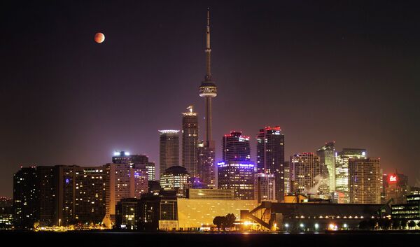 Вид на телевизионную башню Си-Эн Тауэр во время полного затмения луны в Торонто 8 октября 2014