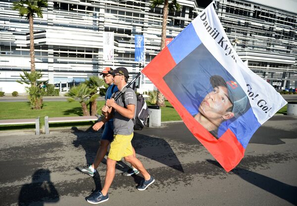 Зрители несут флаг с портретом гонщика команды Торо Россо Даниила Квята