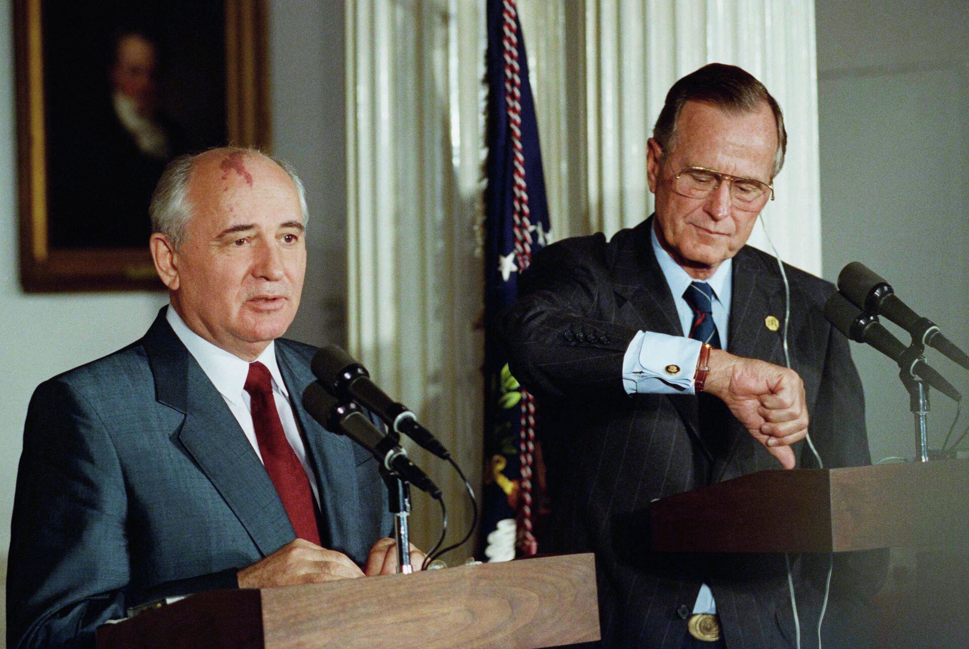 Президент США Джордж Буш смотрит на часы во время совместной пресс-конференции с президентом СССР Михаилом Горбачевым в Лондоне, 1991 год - РИА Новости, 1920, 03.12.2020
