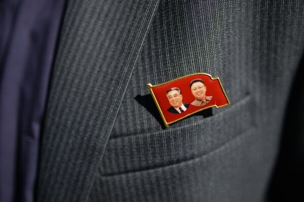 Значок с изображениями Ким Ир Сена и Ким Чен Ира на пиджаке члена корейской делегации