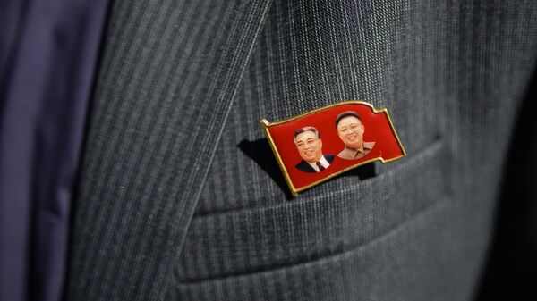 Значок с изображениями Ким Ир Сена и Ким Чен Ира на пиджаке члена корейской делегации