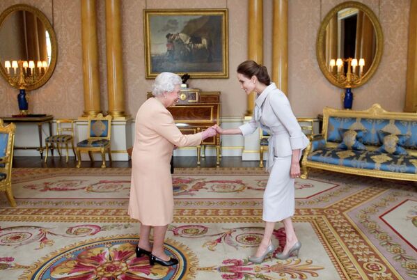 Королева Великобритании Елизавета II приветствует актрису Анджелину Джоли