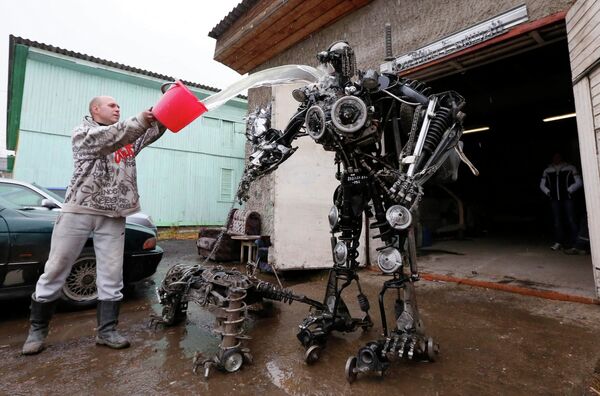 Механик Сергей Кулагин и собранный им из автозапчастей робот Пришелец-самурай