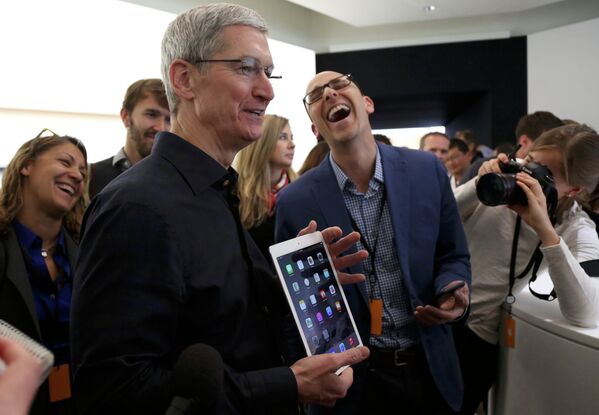 Генеральный директор Apple Тим Кук держит iPad