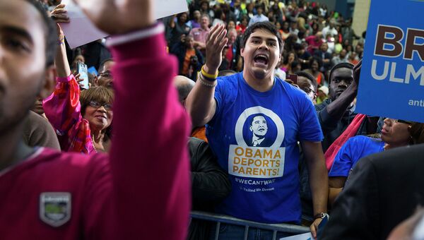 Противник иммиграционной политики президента США перебивает речь Барака Обамы во время его выступления в штате Мэриленд, 19 октября 2014