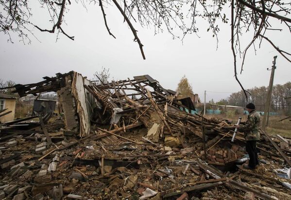 Человек на развалинах дома после обстрела села Спартак, на окраине Донецка