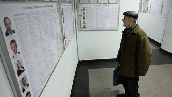 Мужчина читает списки кандидатов на выборах в Верховную раду